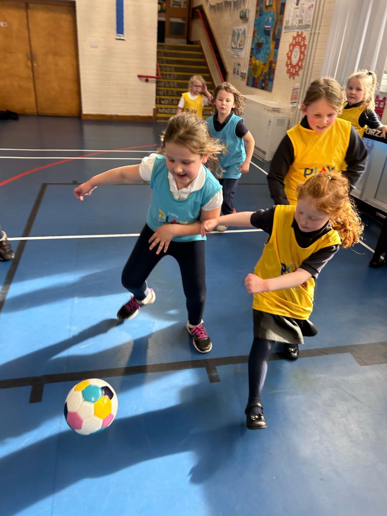 Girls playing football indoors